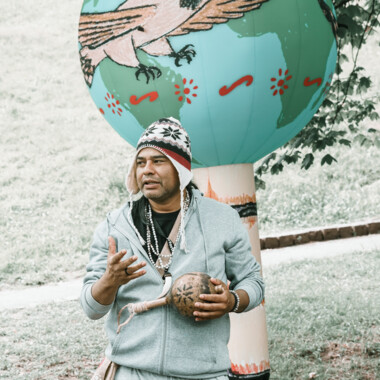 Irineu Nje'a Terena stands in front of an itaaká hanging in a tree and explains something.