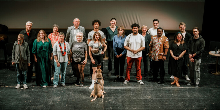 Gruppenfoto: Alle Redner*innen der Veranstaltung stehen als Gruppe zusammen, vor ihnen sitzt ein Hund und schaut die mittig stehende Person an.