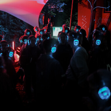 Lots of people with blue headphones dancing in the festival centre.