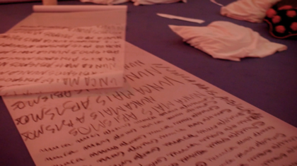 The preview image of the video shows several large white sheets of paper lying on the floor. They are illegibly scrawled with black writing. Next to the sheets of paper, various objects are lying on the floor, for example white and red-blue dotted cushions.