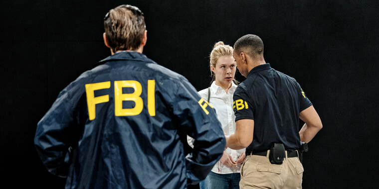 Image description by the editorial staff of Festival Theaterformen. Self-description of the depicted persons follows. / Three people from the waist up. Two of them are wearing T-shirt and jacket with FBI imprint. They are standing in front of the third person. The latter is wearing a white top. 