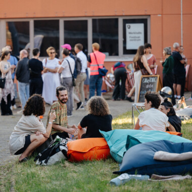 A group of people sitting in the festival center. Some of them are smiling.