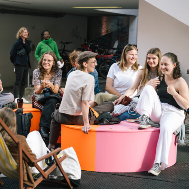 A group of people sitting in the festival center. Some of them are smiling.