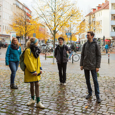 Vier Menschen stehen in der Innenstadt.