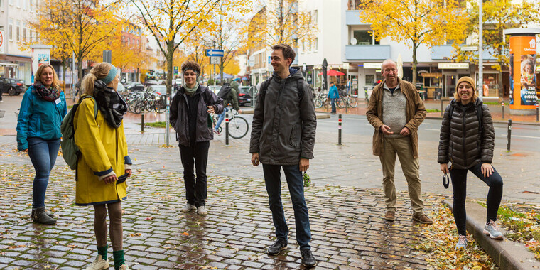 Vier Menschen stehen in der Innenstadt.