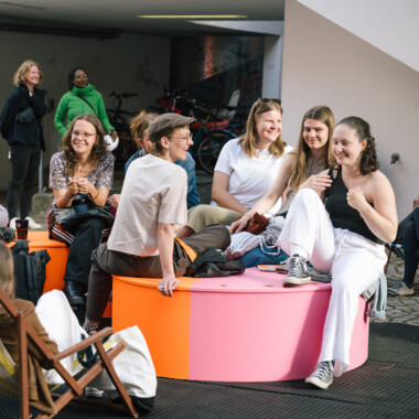 Eine Gruppe von Menschen, die im Festivalzentrum sitzt. Einige von ihnen lächeln.