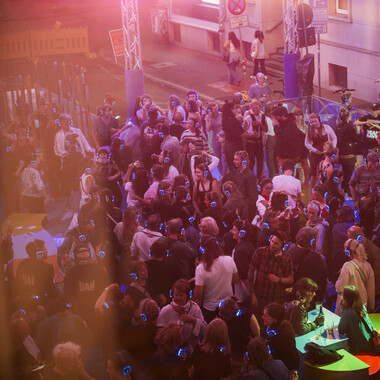 Eine Menschenmenge mit blauen Kopfhörern im Festivalzentrum.