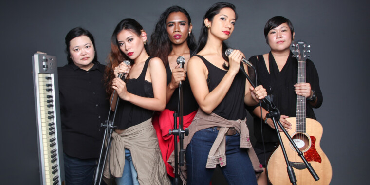 Band photo of the Filipino Superwoman Band. Three people with a microphone in the centre, one person with a keyboard on the left and one person with a guitar on the right.